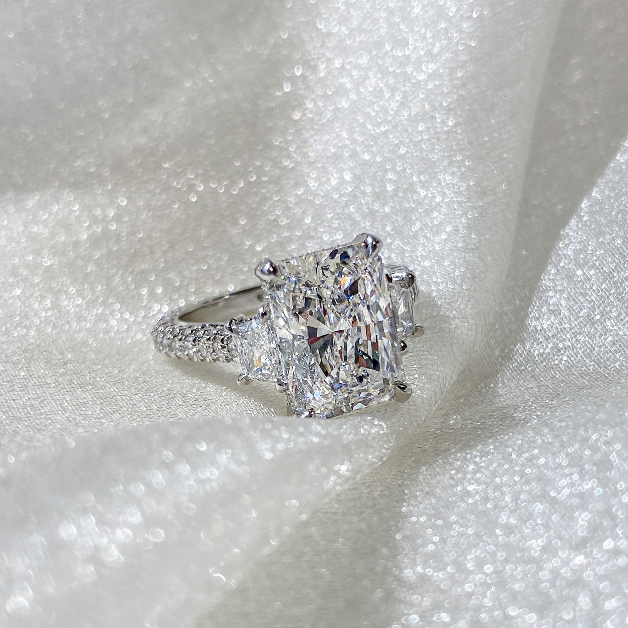 Radiant Cut Three-Stone Engagement Ring with diamonds on band