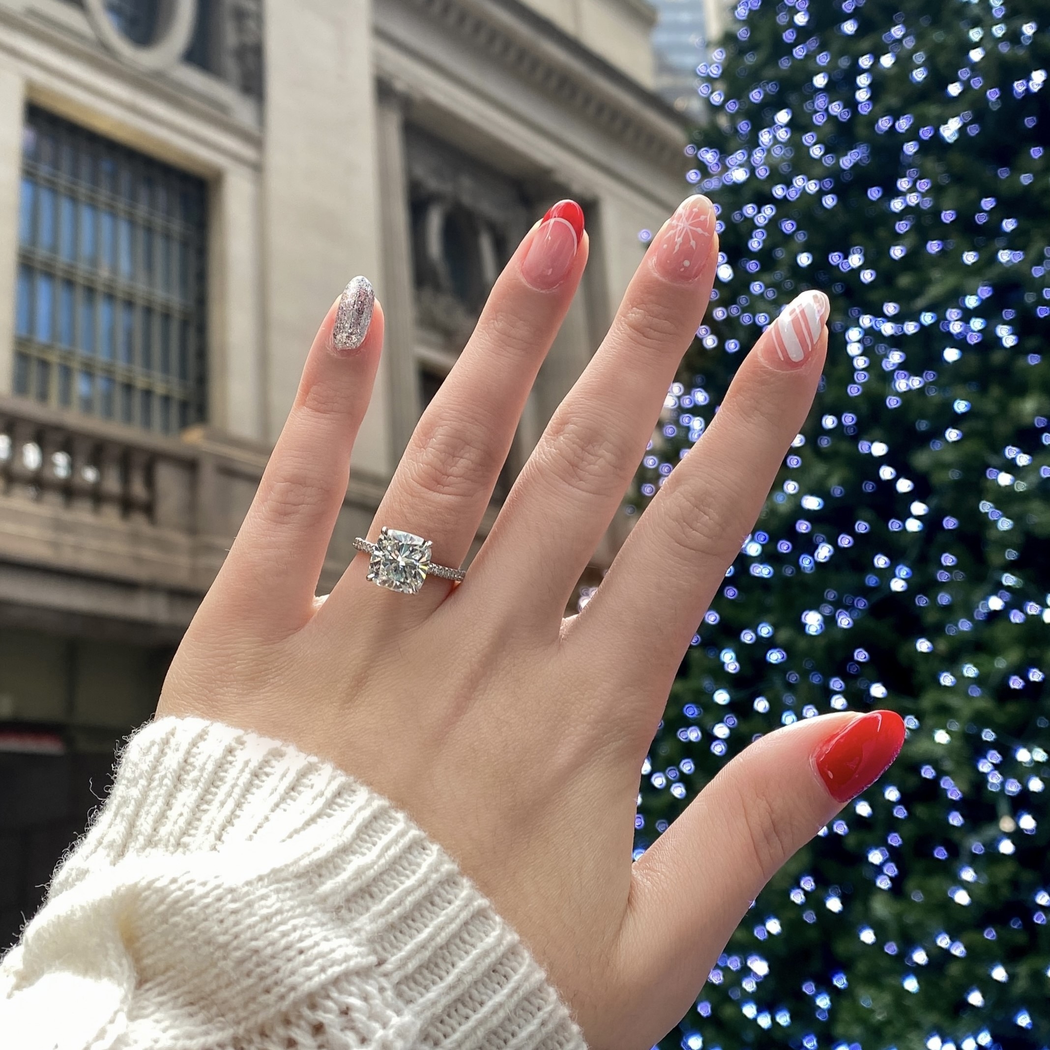 Engagement ring in front of christmas tree